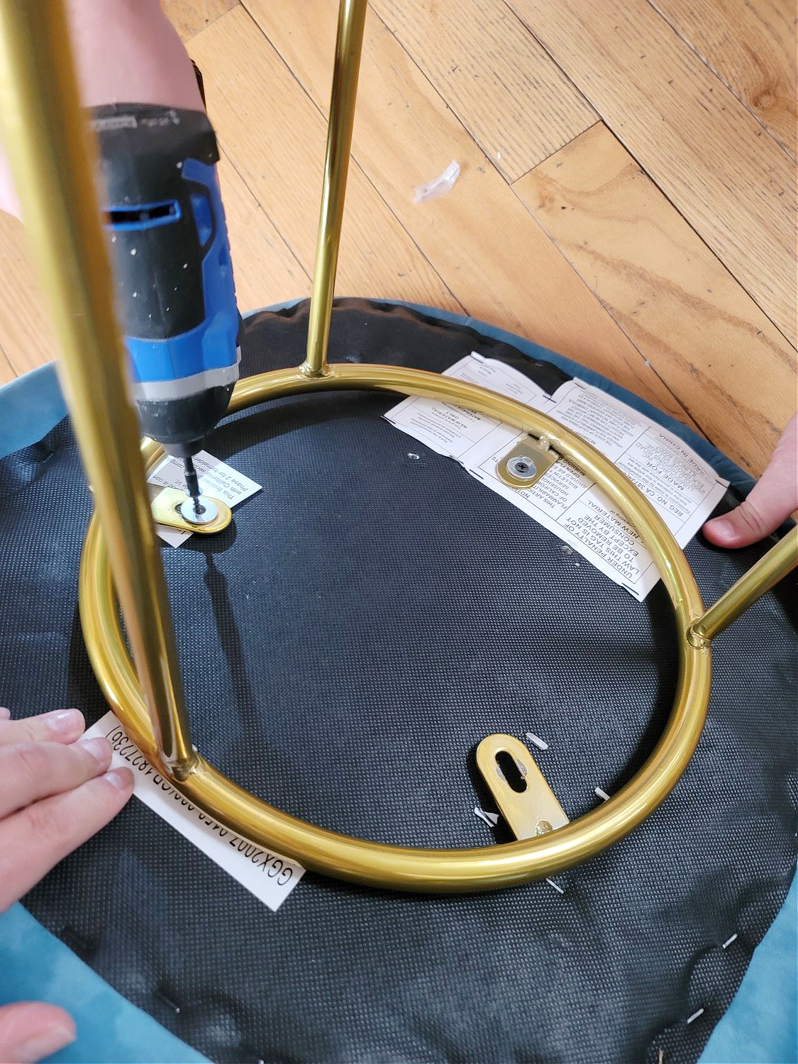 DIY Bar Stools by popular CO Home Design blog, Eclectic Twist: Image of a woman screwing a bar stool together.