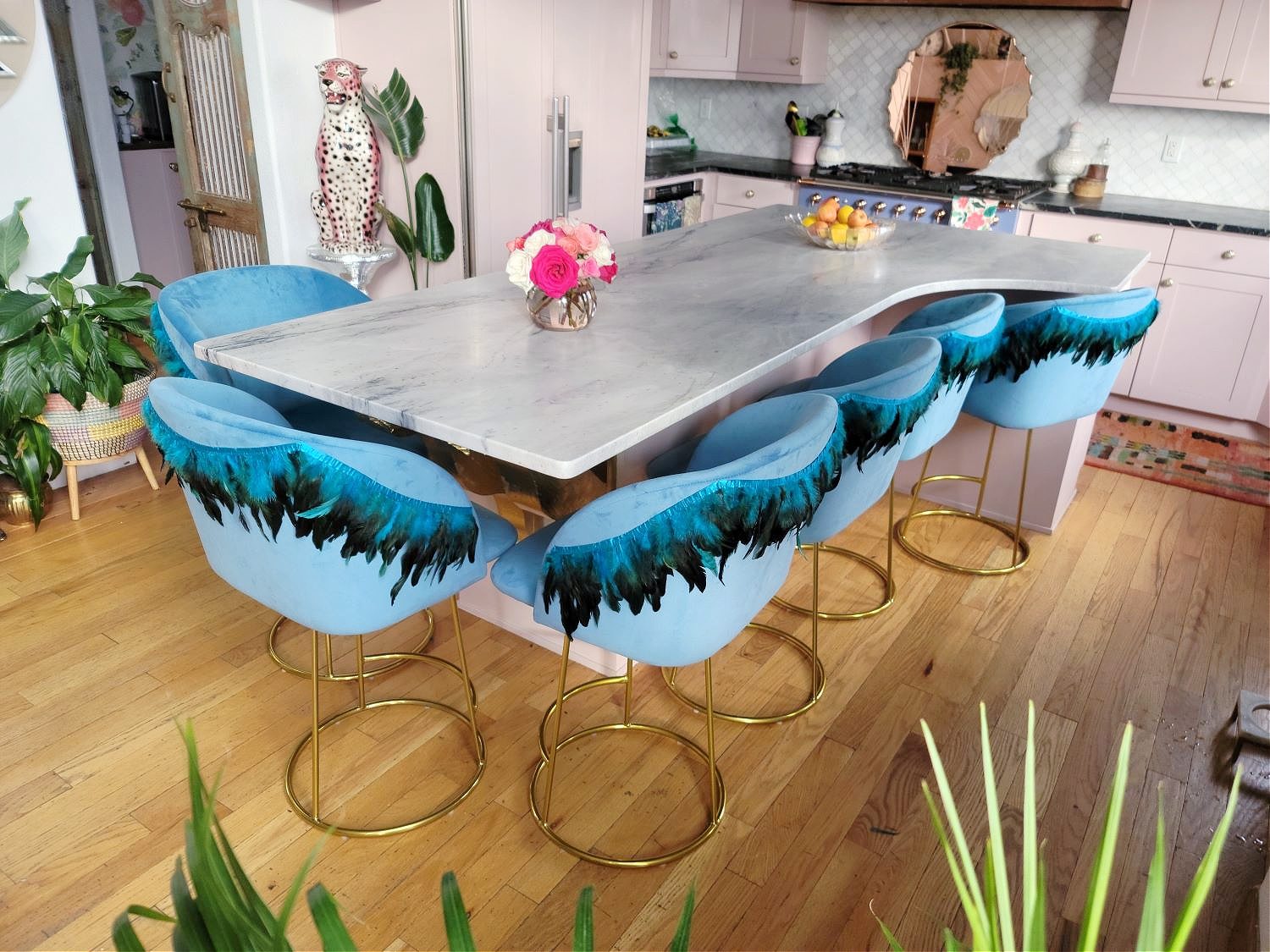 DIY Counter Stools by popular Colorado home design blog, Eclectic Twist: image of blue fabric counter stools with feather trim detailing in a kitchen with pink cabinets and a botanical wallpapered ceiling.