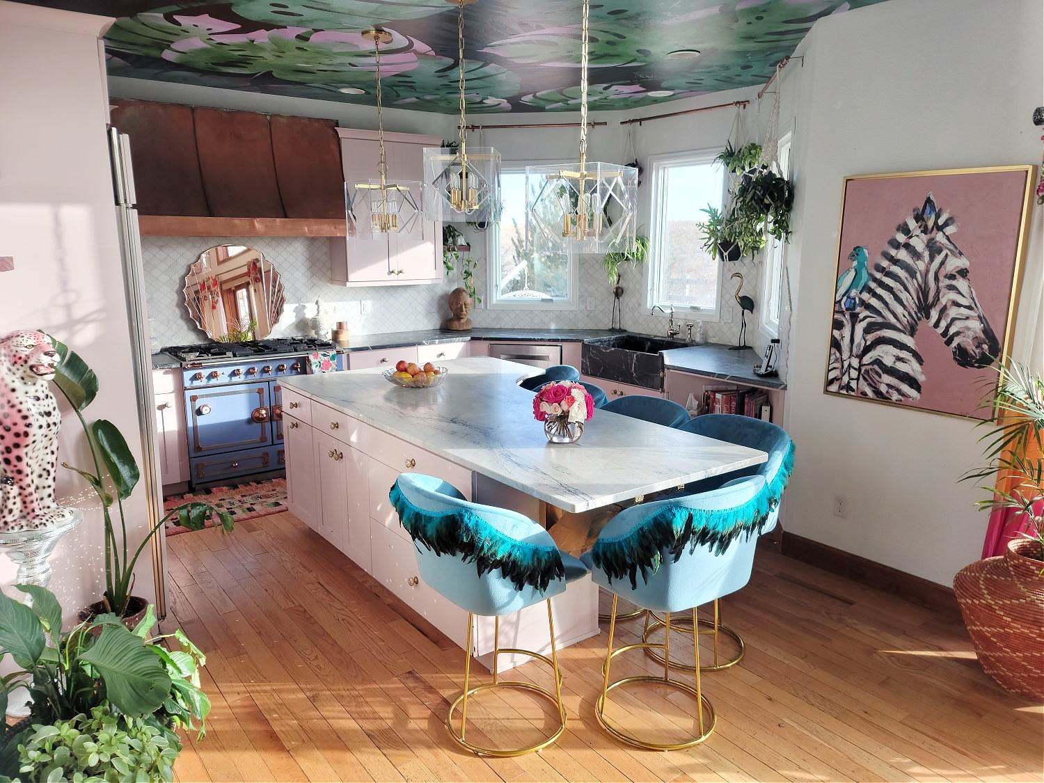 DIY Counter Stools by popular Colorado home design blog, Eclectic Twist: image of blue fabric counter stools with feather trim detailing in a kitchen with pink cabinets and a botanical wallpapered ceiling.