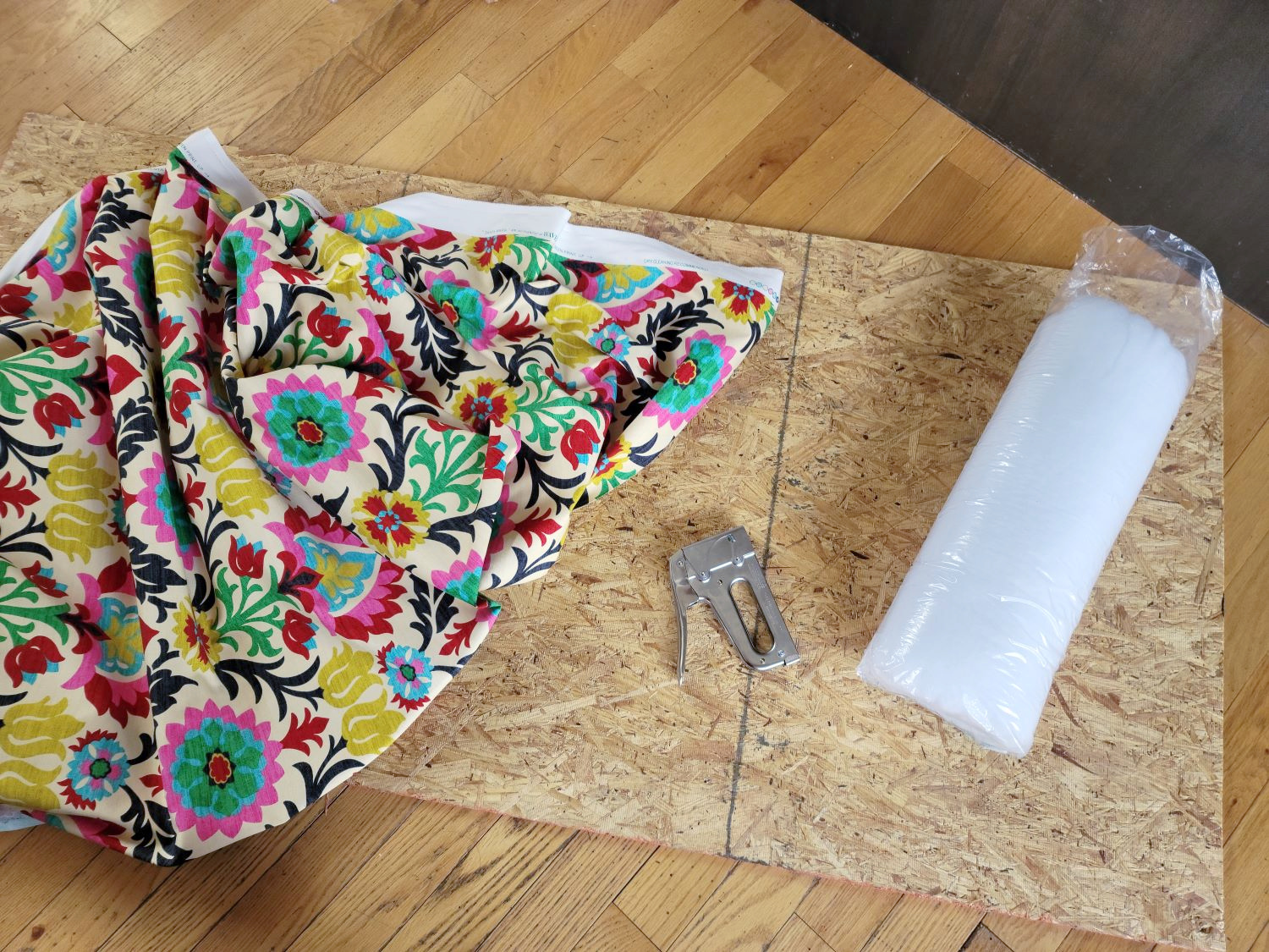 Upholstered Cabinet Panel by popular CO home design blog, Eclectic Twist: image of Waverly fabric, a staple gun, batting, and a plywood board. 