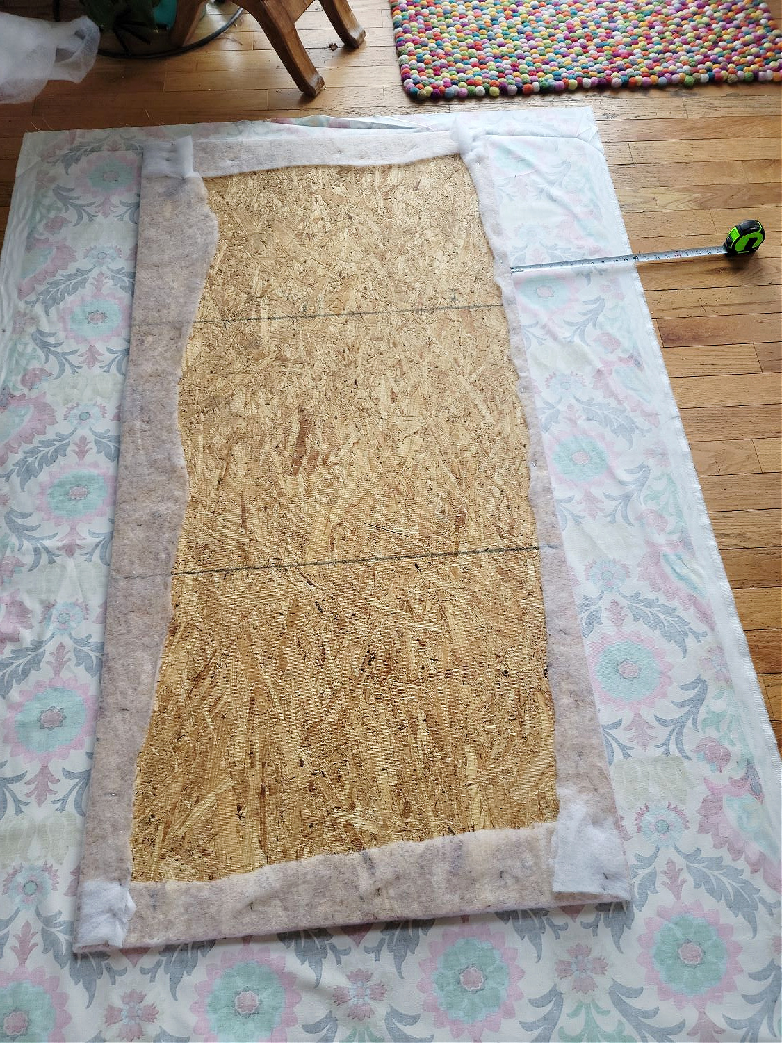 Upholstered Cabinet Panel by popular CO home design blog, Eclectic Twist: image of a batting covered plywood board resting in the middle of some Waverly fabric. 