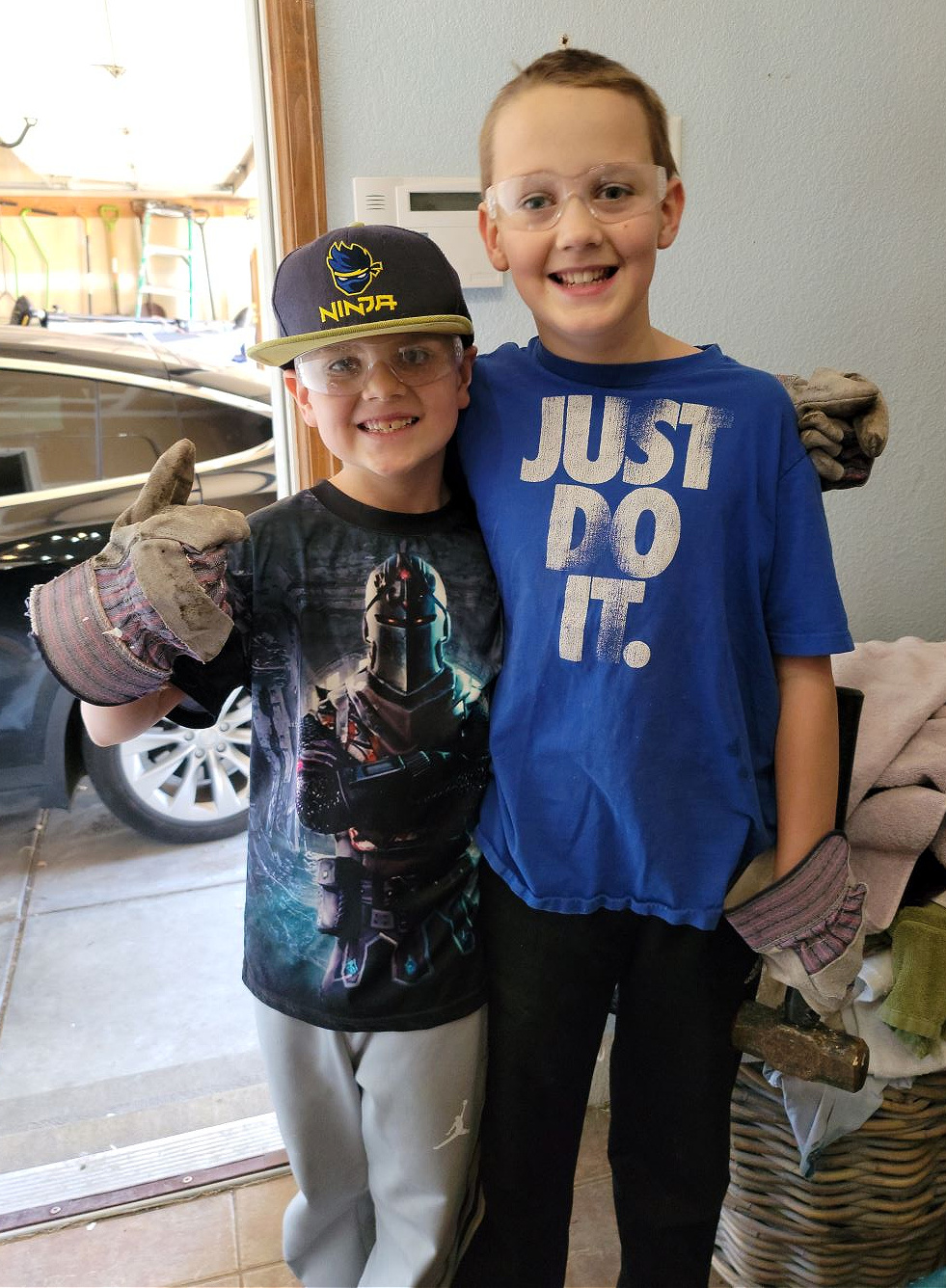 Laundry Room Remodel by popular CO home design blog, Eclectic Twist: image of two young boys standing next to each other wearing goggles, and work gloves and holding a sledgehammer. 