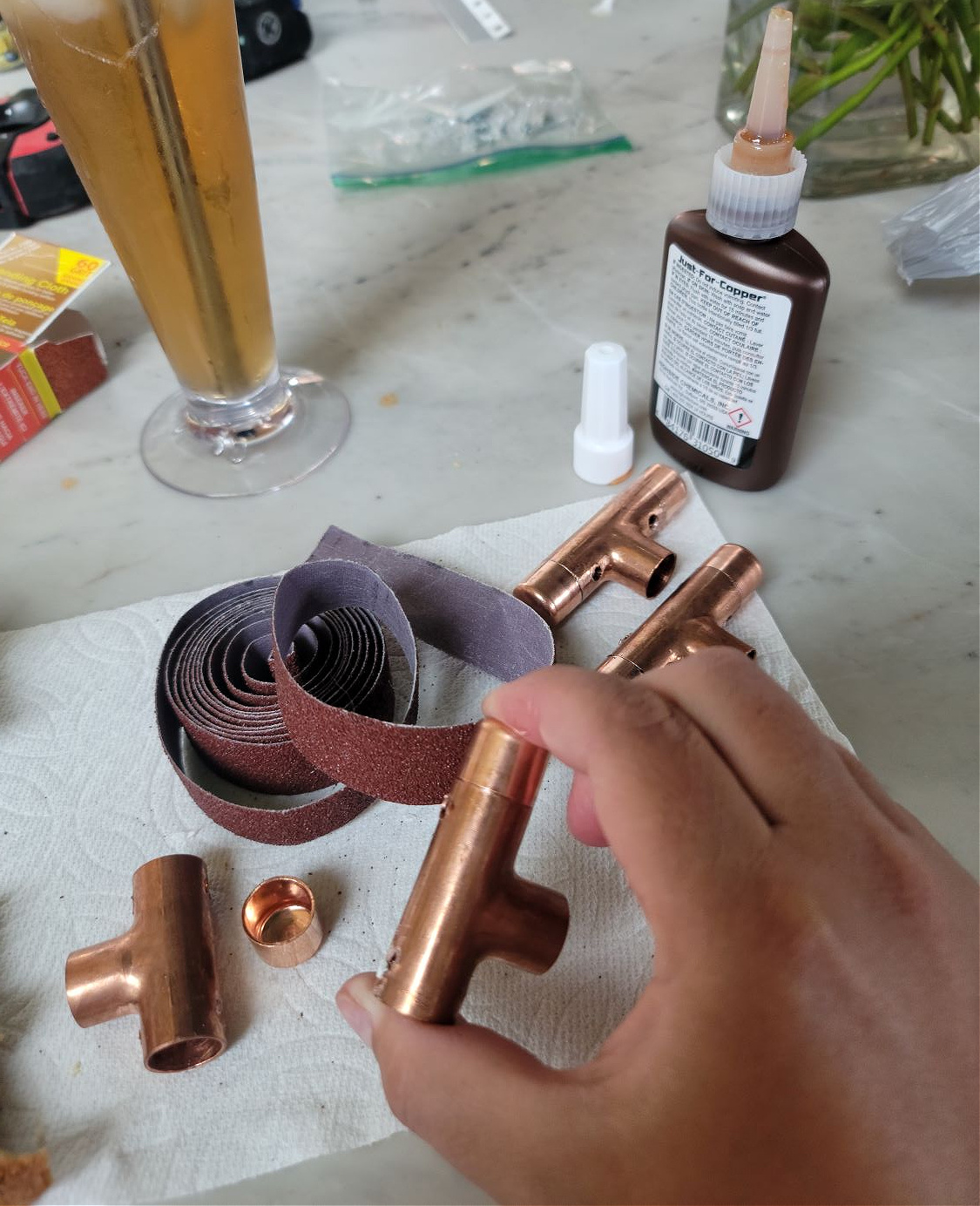 DIY Open Shelving by popular CO home design blog, Eclectic Twist: image of a person holding a copper T piece. 