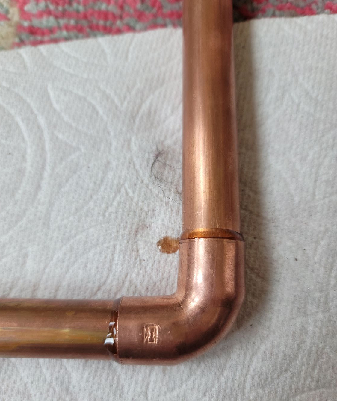 DIY Open Shelving by popular CO home design blog, Eclectic Twist: image of two copper bars being held together with a copper elbow piece. 