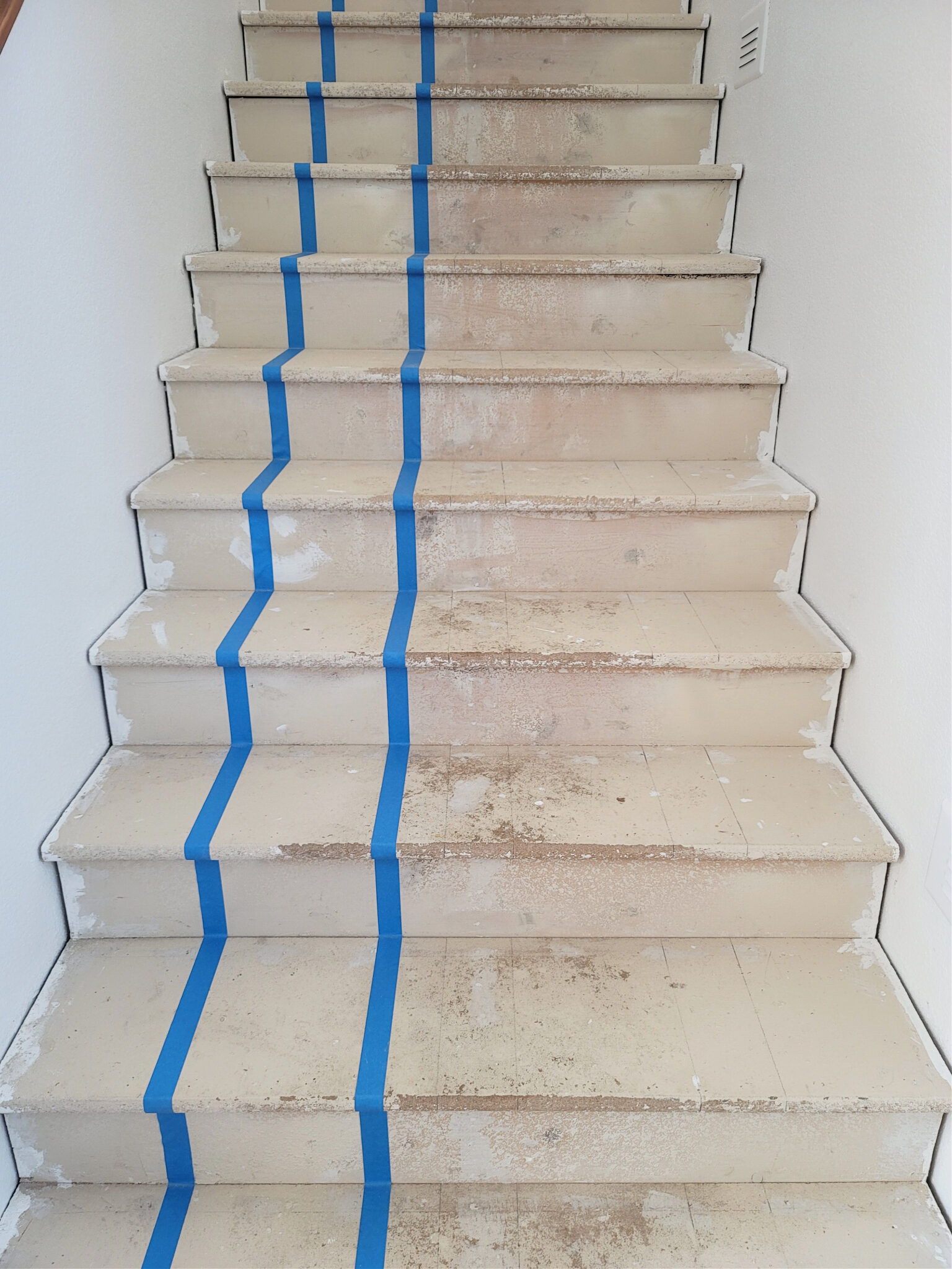 Staircase Makeover by popular CO home design blog, Eclectic Twist: image of a wooden staircase with painter's tape on it. 