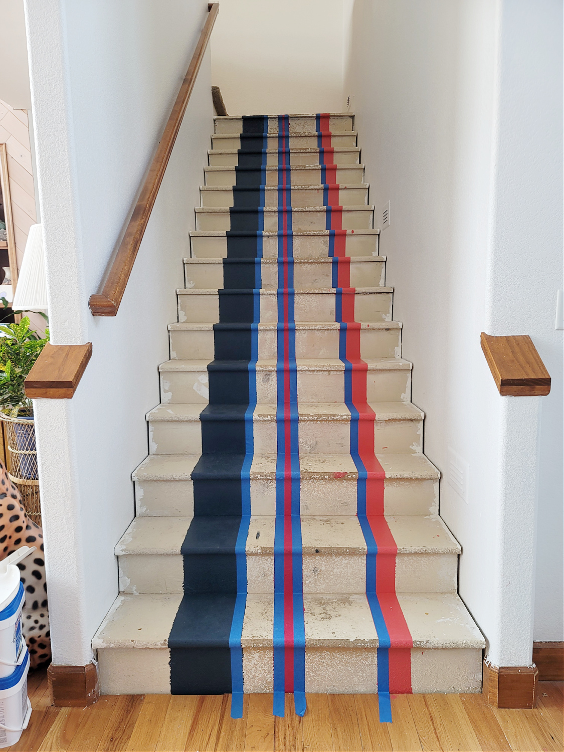 Staircase Makeover by popular CO home design blog, Eclectic Twist: image of a wooden staircase with navy blue, pink and orange stripes painted on it. 