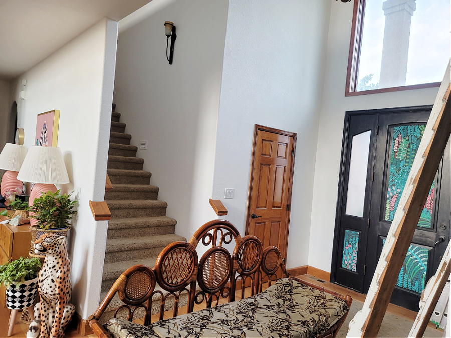 Staircase Makeover by popular CO home design blog, Eclectic Twist: image of a carpeted staircase near a black front door with jungle print contact paper.